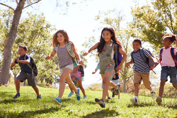 istock Multi-ethnic group of schoolchildren running in the park 1031376236