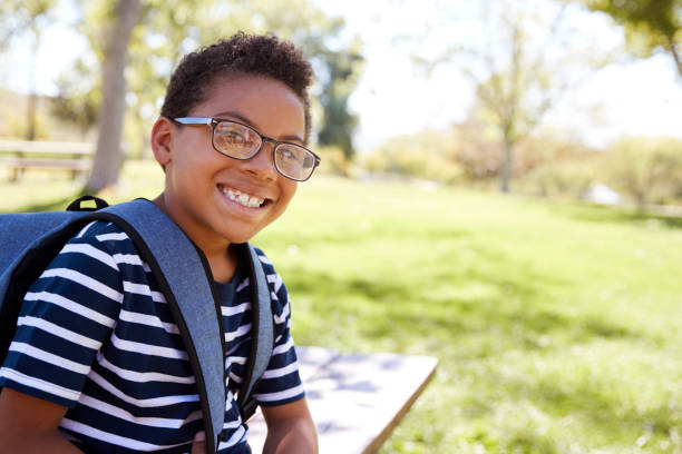 Young mixed race schoolboy in glasses smiling to camera Young mixed race schoolboy in glasses smiling to camera 12 13 years stock pictures, royalty-free photos & images