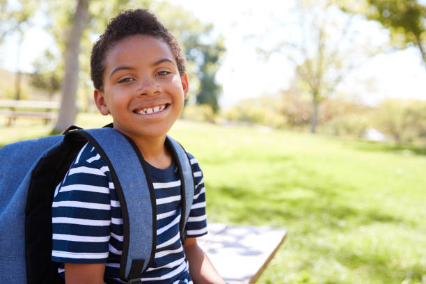 istock Young mixed race schoolboy with backpack smiles to camera 1031376478