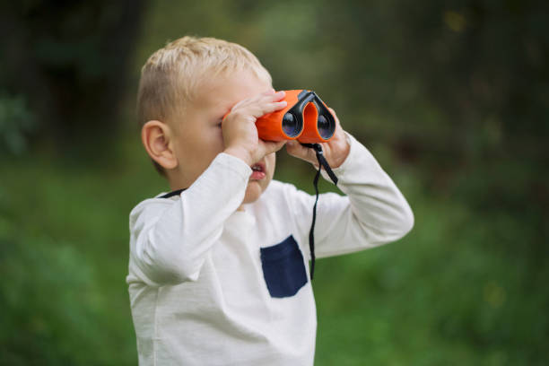 istock The little boy young researcher exploring with binoculars environment 1031376568