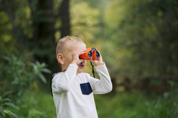 istock The little boy young researcher exploring with binoculars environment 1031376620