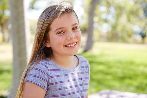 Young smiling schoolgirl looking to camera, close up portrait