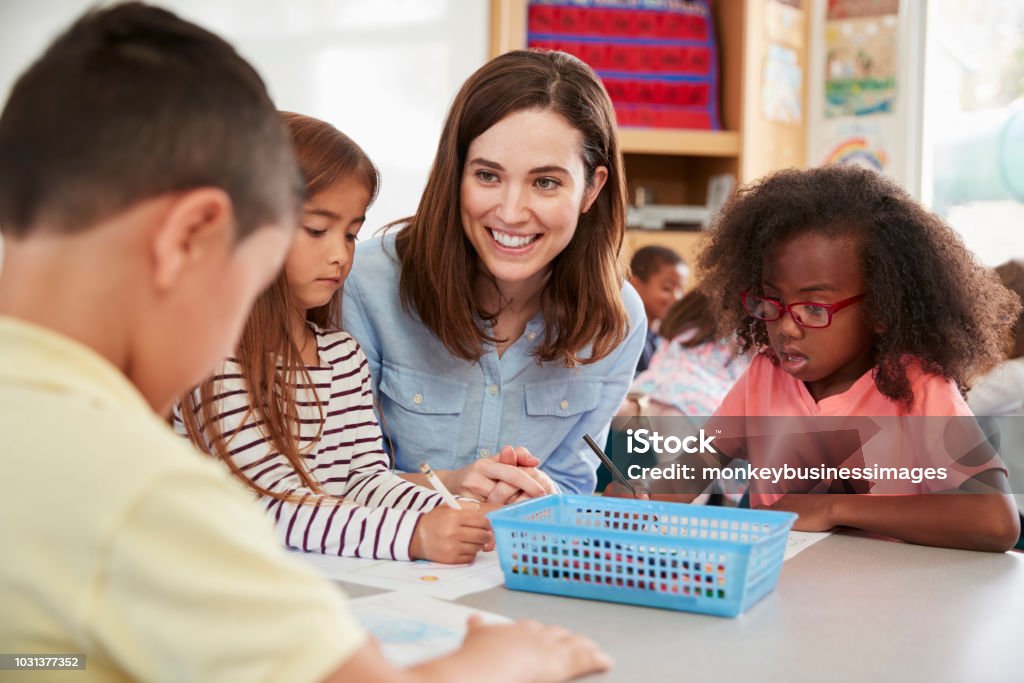 Profesor de la escuela primaria femenina y los niños en clase, de cerca - Foto de stock de Maestro libre de derechos