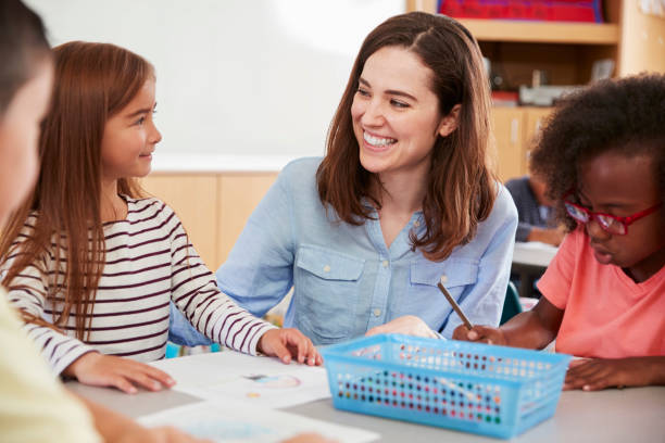 istock Teacher and primary school kids sitting in class, close up 1031377354