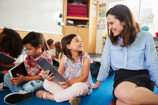 istock Teacher and kids sitting on the floor in elementary class 1031377684