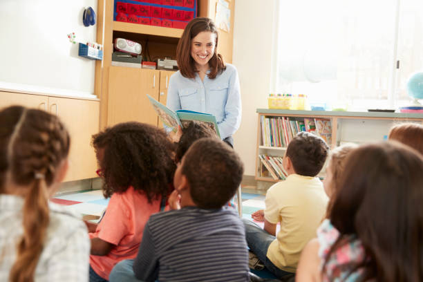 istock Elementary school kids listen to teacher in class, back view 1031377824