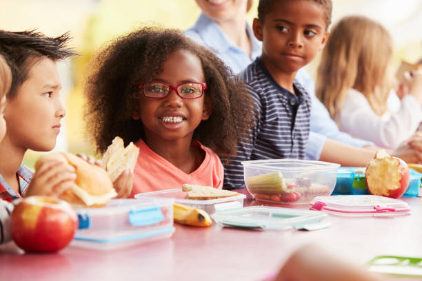 istock School kids eating packed lunches together at a table 1031379604