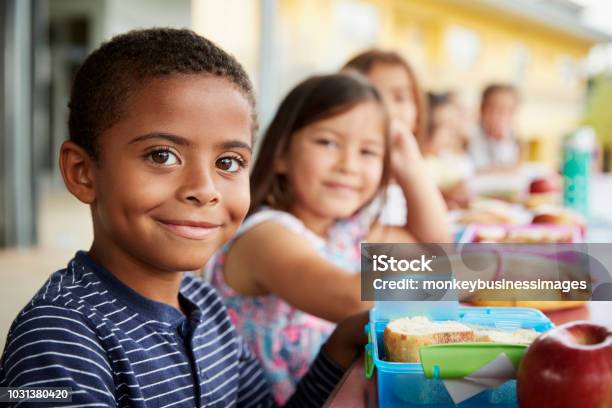 Young Boy And Girl At School Lunch Table Smiling To Camera Stock Photo - Download Image Now