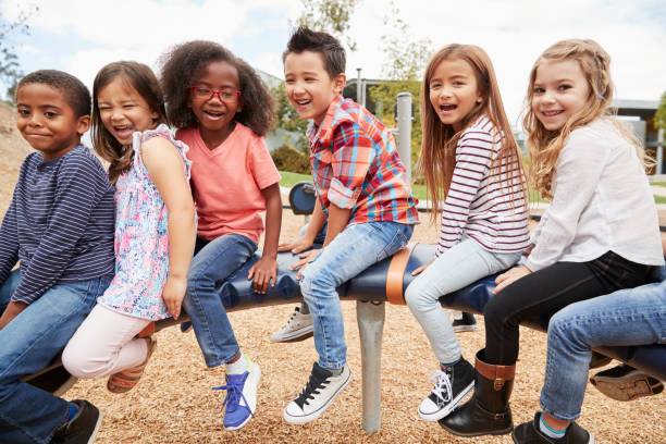 istock Kids sitting on a carousel in their schoolyard, side view 1031380834
