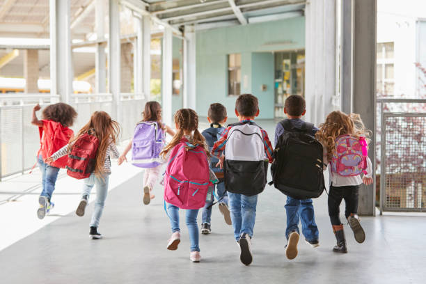istock Elementary school kids run from camera in corridor, close up 1031384150