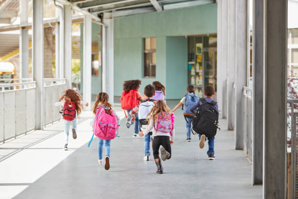 istock Elementary school kids run from camera in school corridor 1031384156