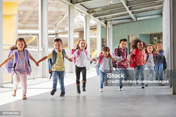 Primary School Kids Run Holding Hands In Corridor Close Up Stock Photo - Download Image Now