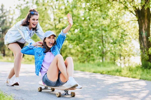 istock Two friends having fun with longboard outdoors in the summer 1031390120