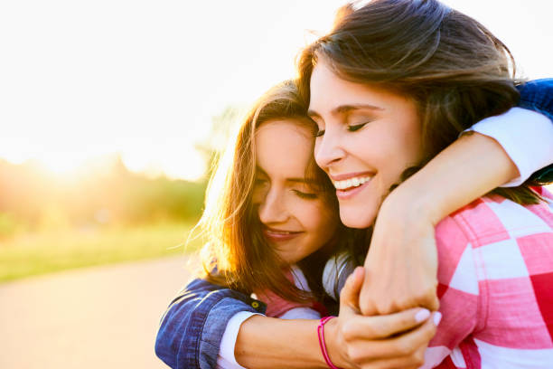 istock Couple of young women hugging outdoors during sunset 1031390936