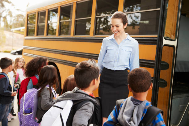 istock School teacher preparing kids to get on the school bus 1031391122