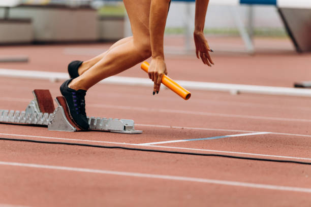 istock start female runner with baton in hand relay race running 1031392648