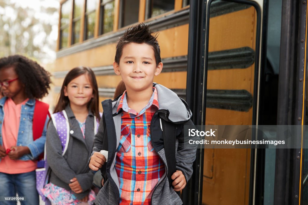 École primaire les enfants files d’attente pour le bus de l’école - Photo de Bus scolaire libre de droits