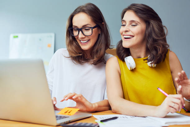 istock Two univeristy students working together. Female entrepreneur working with laptop 1031397108