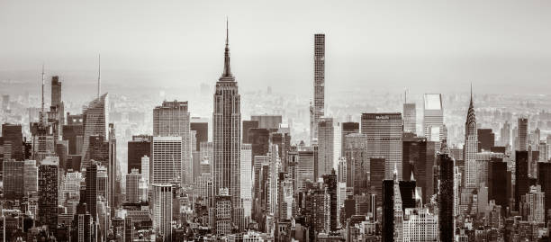 A panoramic toned black and white view of the towers and buildings of Midtown Manhattan from Lower Manhattan.