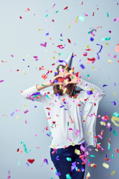 istock Joyful girl celebrating making heart gesture with birthday hat on her head 1031397568