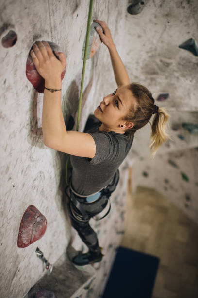 istock Athletic woman making an effort during wall climbing in bouldering gym. 1031398078