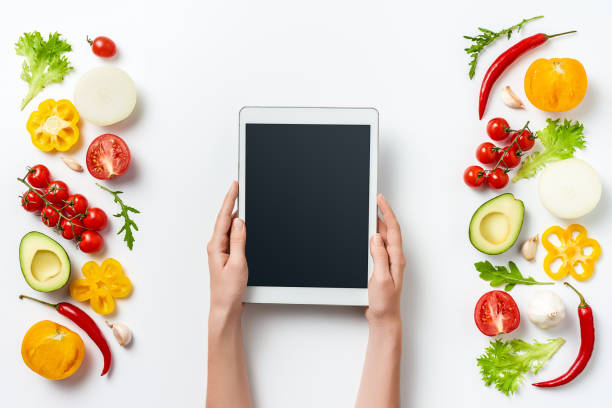 istock digital tablet in woman hands and herbs and vegetables isolated on white background. Copy space 1031400894