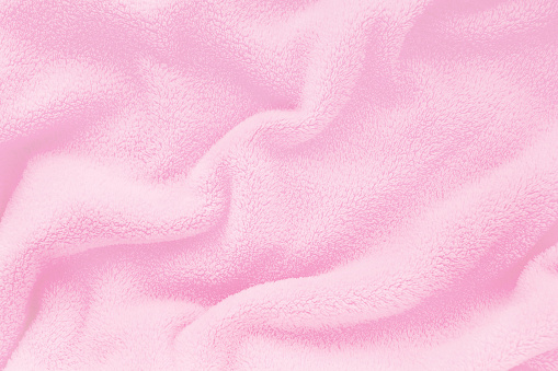 Fluffy Gentle baby pink fabric with waves and folds. Soft pastel textile texture. Folds on the soft fabric. Rose towel terry cloth.