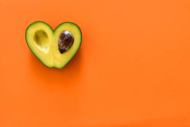 istock Heart-shaped avocado on orange background 1031411682