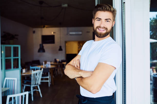 istock Cheerful young business owner looking at camera with arms crossed while in his restaurant 1031414700
