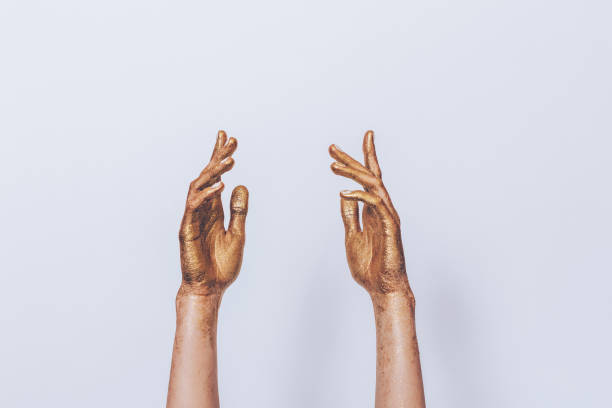 istock Women's hands painted golden sequins lifted upwards 1031419326