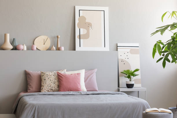 istock Light grey bedroom interior with king-size bed with many cushions, simple posters and decor in the real photo 1031429106