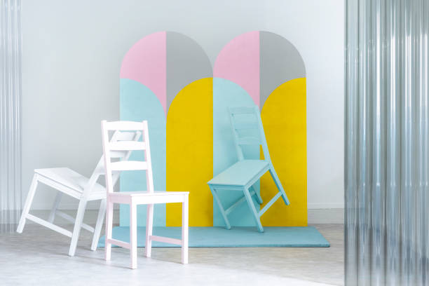 istock Pastel chairs and geometric screen in bright studio interior with white walls. Real photo 1031430136