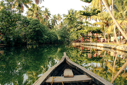 The front of a boat can be seen travelling through the backwaters of Monroe Island in Kollam District, Kerala, South India.