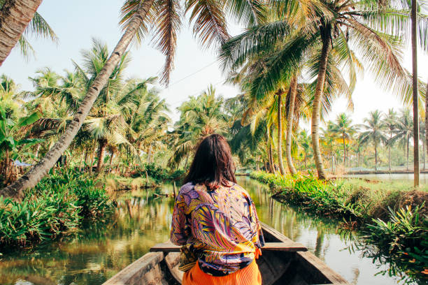 Young Woman Kayaking Through the Backwaters of Monroe Island A young woman kayaks through the backwaters of Monroe Island in Kollam District, Kerala, South India. india stock pictures, royalty-free photos & images