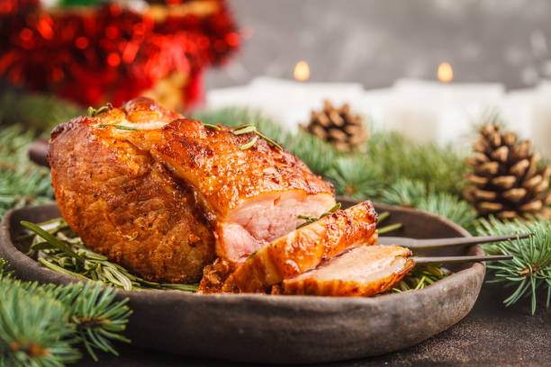 istock Baked Christmas pork (ham) with rosemary on Christmas table 1031436116
