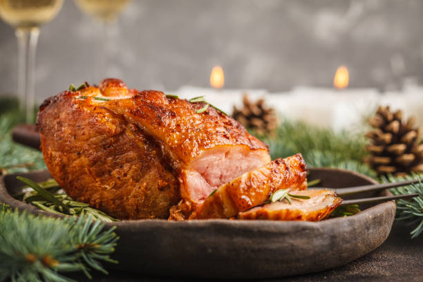 istock Baked Christmas pork (ham) with rosemary on Christmas table 1031436184