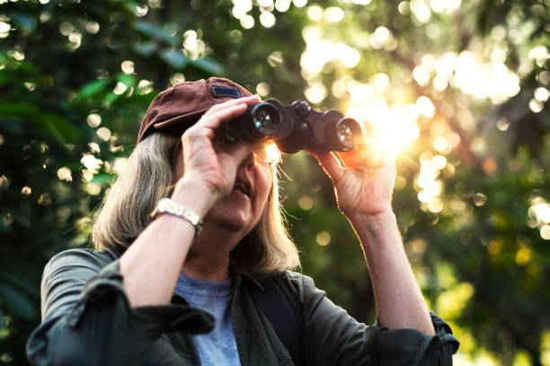 istock Elderly woman watching birds with binoculars 1031436692