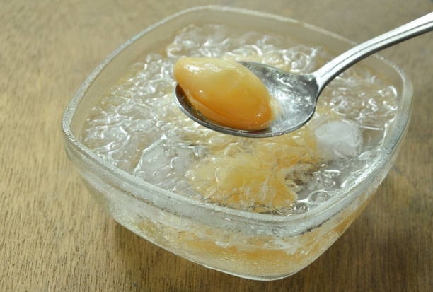 salacca senza semi di sciroppo e ghiaccio scooping sul cucchiaio - soft cider foto e immagini stock