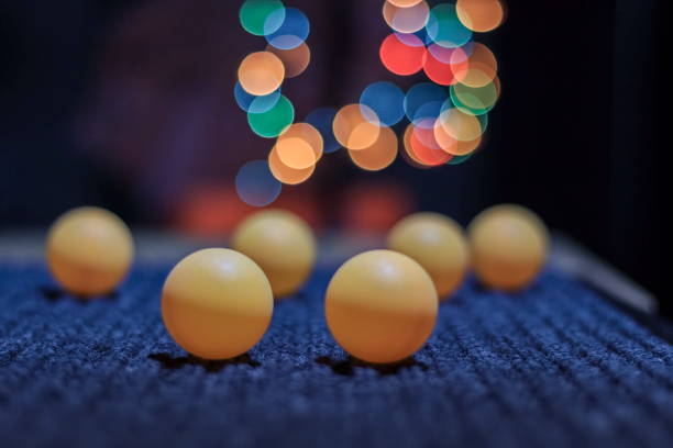 istock Yellow ping pong ball, with bokeh background, on black background 1031455194