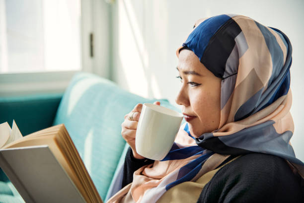 Islamic woman reading and drinking coffee