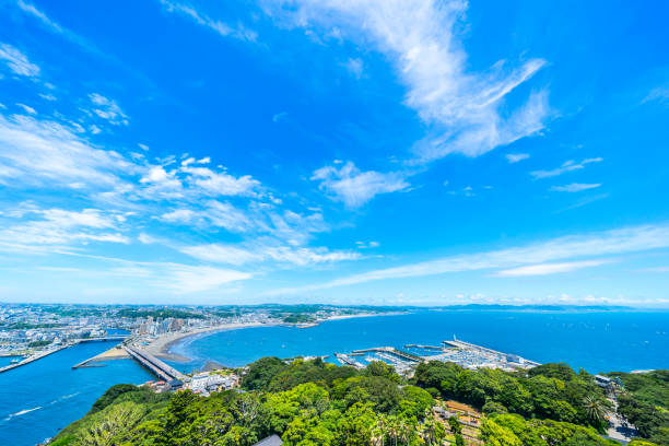 enoshima island and urban skyline aerial view in kamakura, Japan Asia travel concept -  the famous travel place, enoshima island and urban skyline aerial panoramic view under dramatic blue sky and beautiful ocean in kamakura, Japan. kamakura city photos stock pictures, royalty-free photos & images