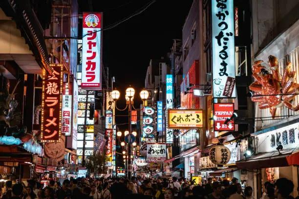 OSAKA, JAPAN - AUGUST 3, 2018: Famous Dotonbori shopping street of Osaka with thousands of people and neon signs everywhere during night