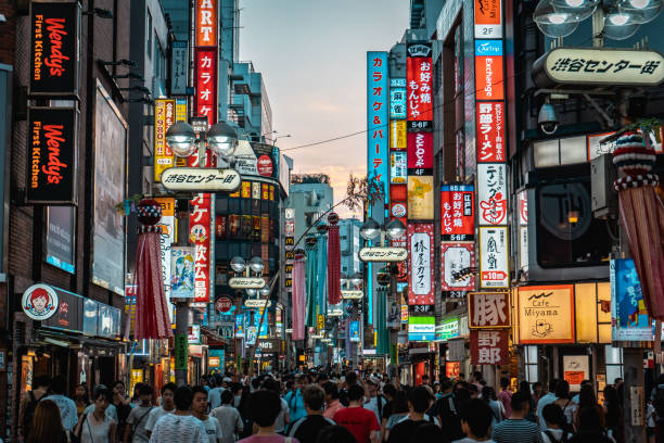 View of Shibuya shopping street with thousands of people TOKYO, JAPAN - AUGUST 5, 2018: View of Shibuya shopping street with thousands of people and neon signs during sunset tokyo japan stock pictures, royalty-free photos & images