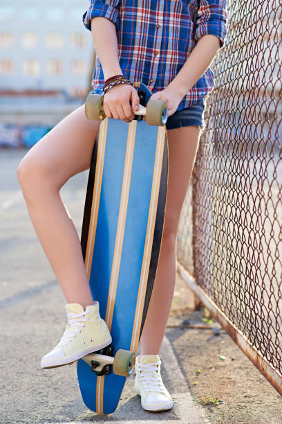 istock Girl Holding Striped Longboard 1031469058