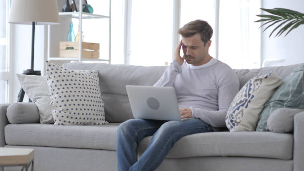 istock Man Working on Laptop with Headache, Pain in Head 1031471876