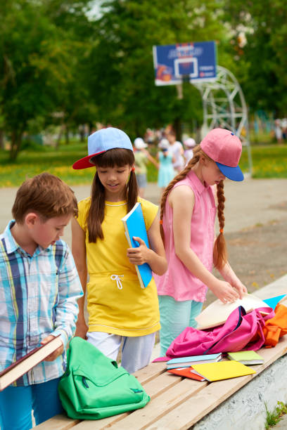 istock Schoolchildren preparing textbooks on bench 1031473940
