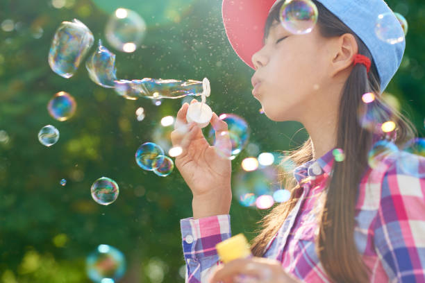 istock Girl blowing bubbles in park 1031476064