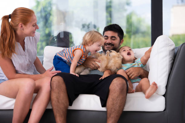 istock Family sitting on sofa. Father hugging kids. 1031476252