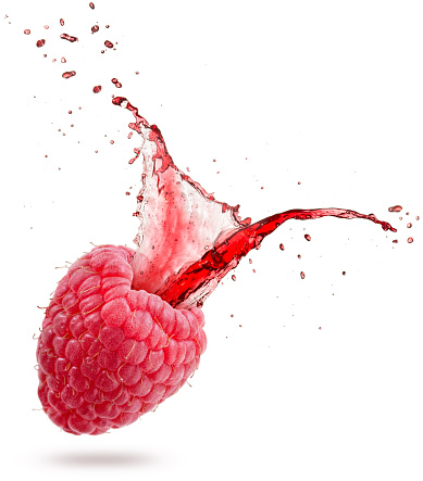 red juice splashing out of a raspberry isolated on white background