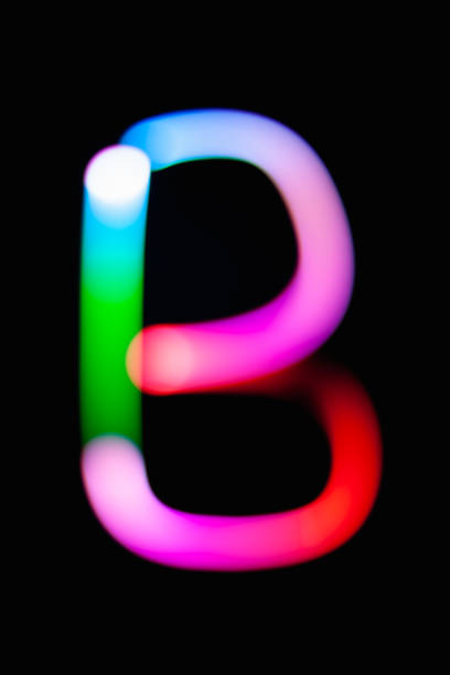 istock Letter B. Glowing letters on dark background. Abstract light painting at night. Creative artistic colorful bokeh. New Year. Use it for build you own design for book cover, CD, poster or post card. 1031481764